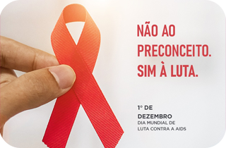 Descrição: Arte na qual vemos a fitinha da campanha em prol da luta contra a AIDS, do lado esquerdo. No lado direito, lemos: "Não ao preconceito, sim à luta". Na parte inferior, tem escrito: "1º de dezembro - Dia Mundial de Luta Contra a AIDS". 